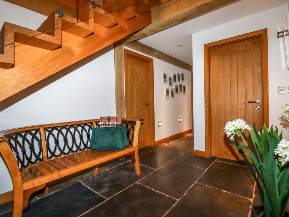 A hallway with a bench and staircase at Kerslake House Crafthole