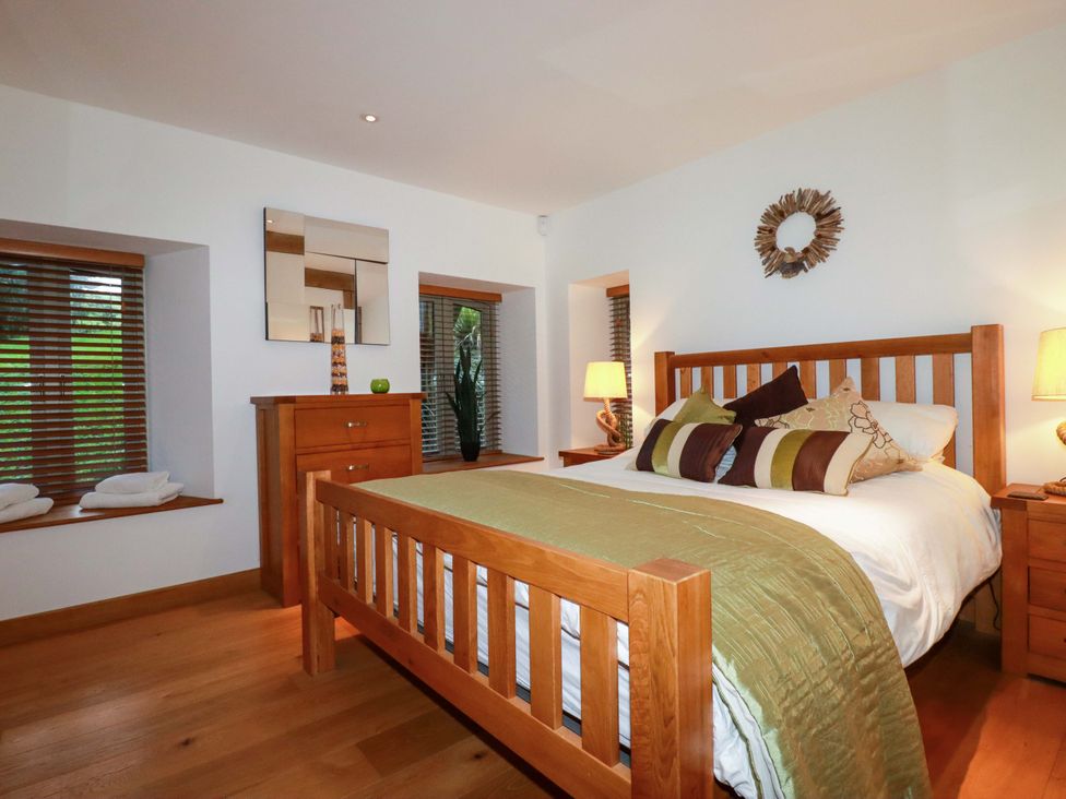 A bedroom with wooden furniture and a bed at Kerslake House Crafthole