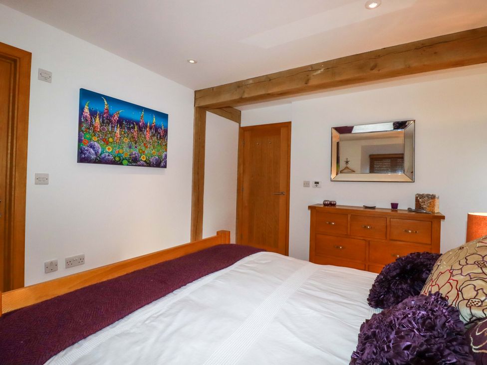 A bedroom with a bed and a mirror at Kerslake House in Crafthole