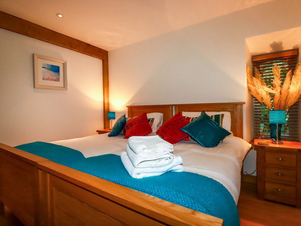 A bedroom with a bed and nightstand at Kerslake House Crafthole