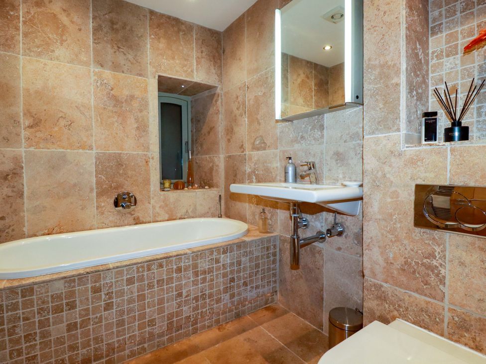 A bathroom with a bathtub, sink, and toilet at Kerslake House in Crafthole
