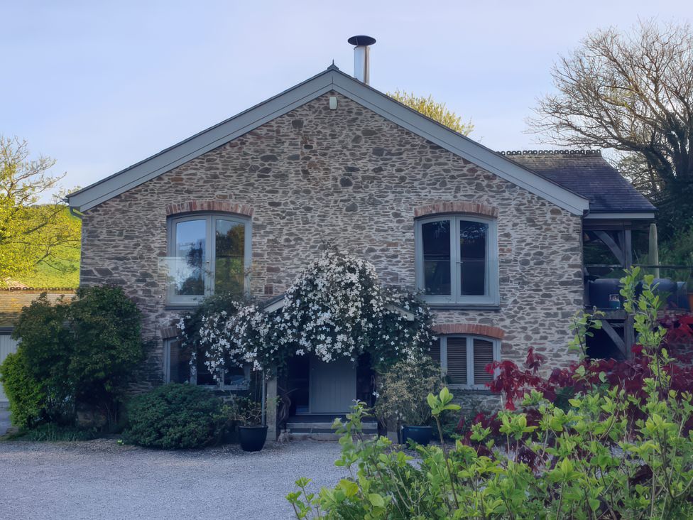 A stone house with windows and plants at Kerslake House in Crafthole