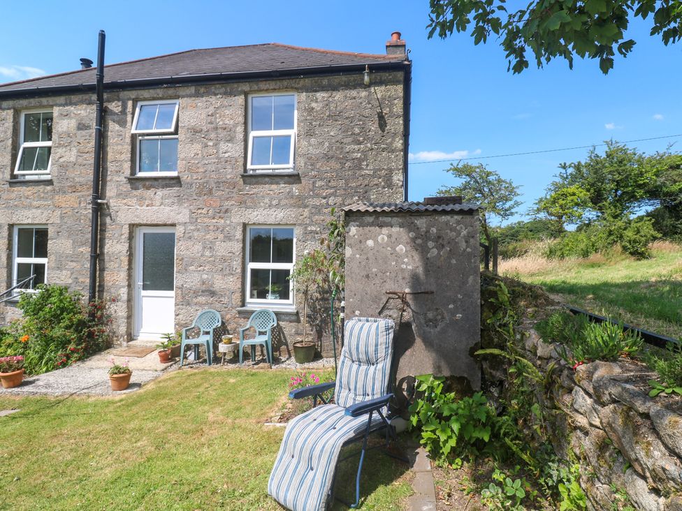 A garden with lawn chairs and plants at Halwyn Farm in Helston