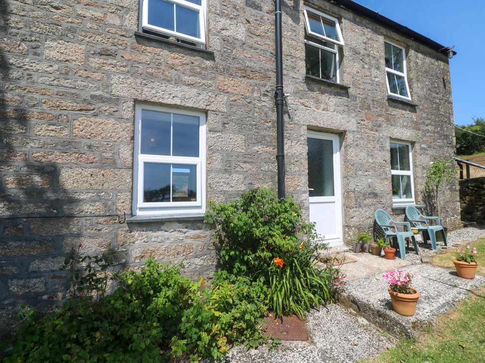 An outdoor area with stone walls and patio at Halwyn Farm in Helston
