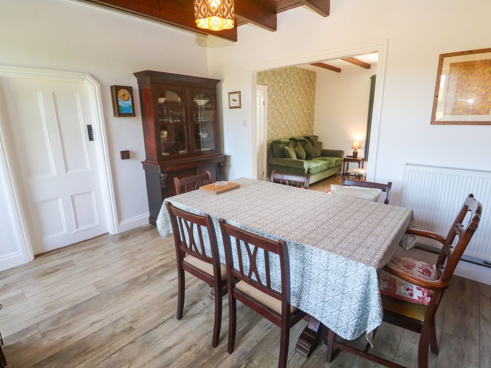 A dining room with a table and chairs at Halwyn Farm in Helston