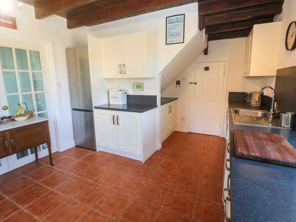 A kitchen with cabinets and appliances at Halwyn Farm in Helston