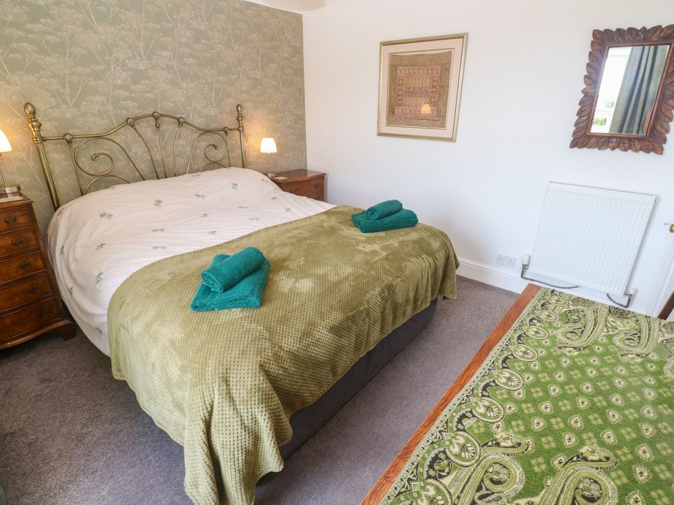A bedroom with a bed and bedside table at Halwyn Farm in Helston