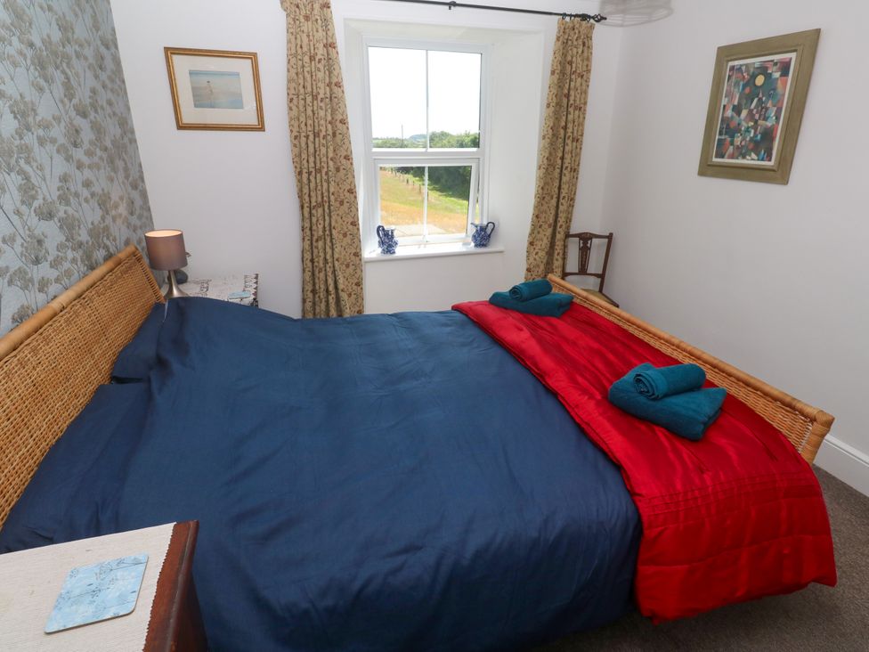 A bedroom with a bed and a window at Halwyn Farm in Helston