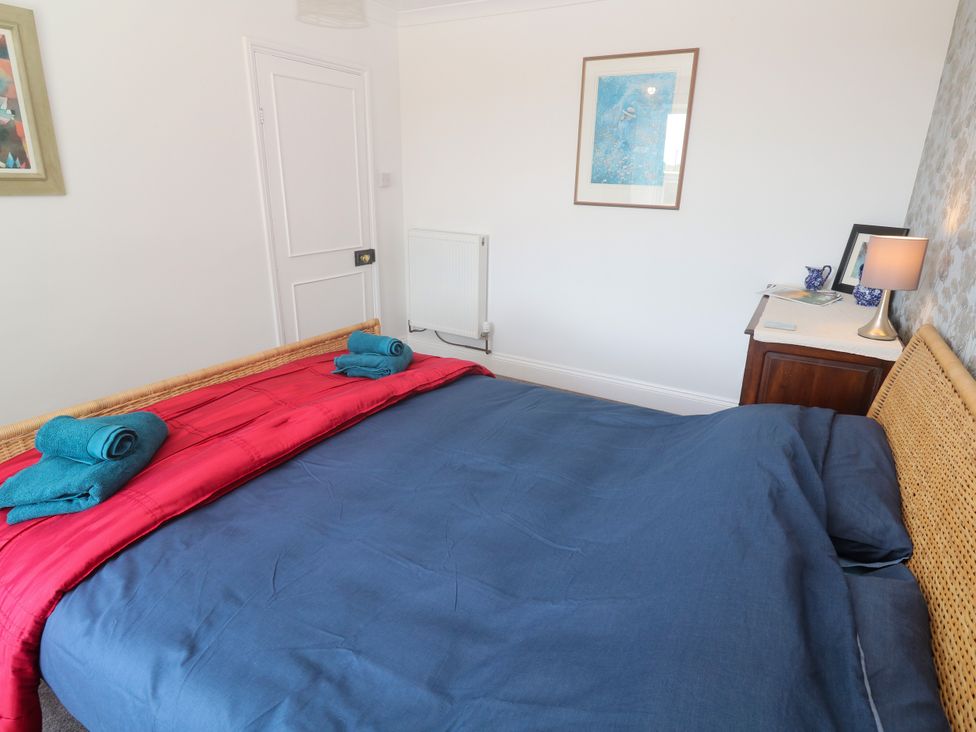 A bedroom with a bed and dresser at Halwyn Farm in Helston
