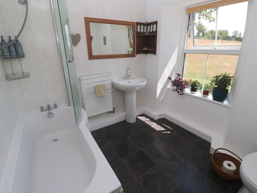 A bathroom with a bathtub and sink at Halwyn Farm in Helston