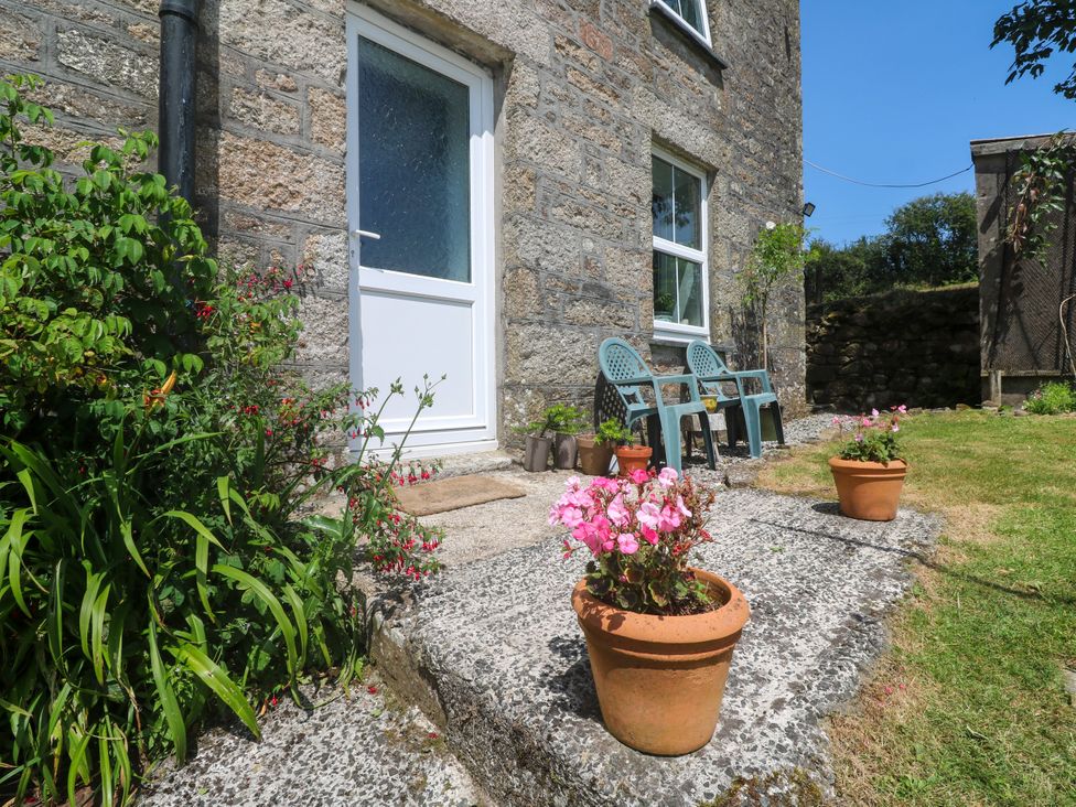 A door with chairs and potted plants at Halwyn Farm Helston