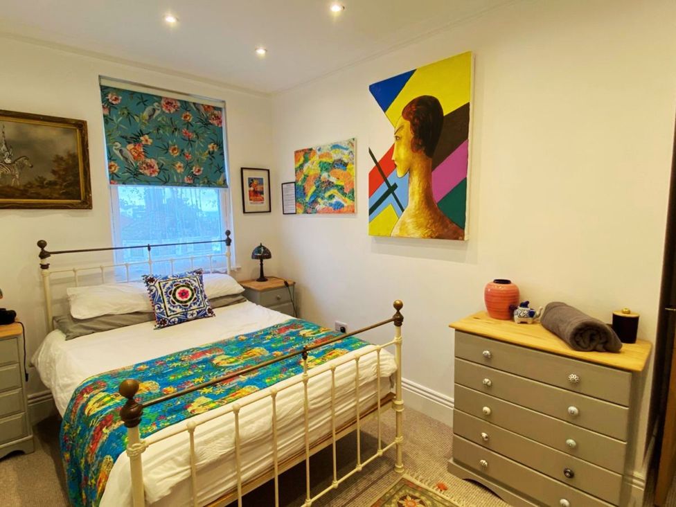 A bedroom with a bed, bedside lamp and artwork at 21 Gensing Road St. Leonards-on-Sea