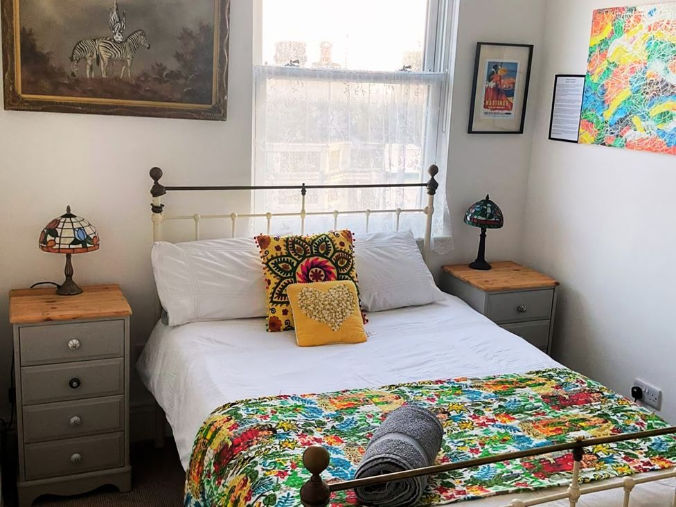 A bedroom with a bed and artwork on the walls at 21 Gensing Road St. Leonards-on-Sea