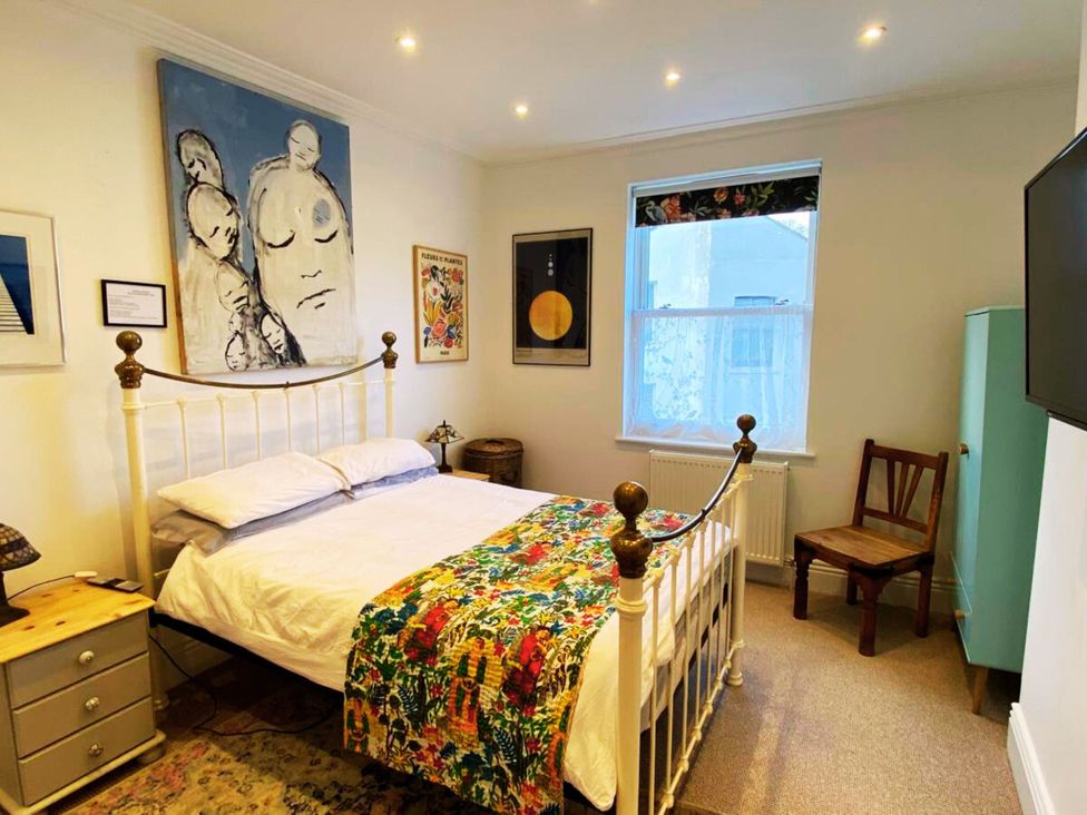 A bedroom with a bed and artwork on the walls at 21 Gensing Road St. Leonards-on-Sea