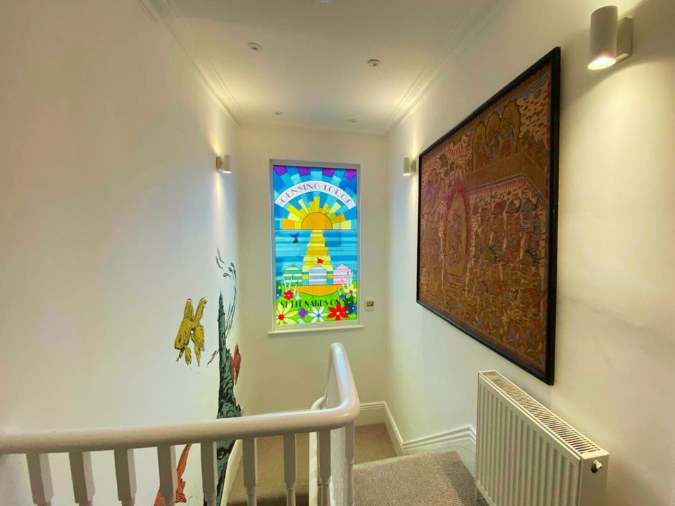 A hallway with a stained glass window and wall art at 21 Gensing Road St. Leonards-on-Sea