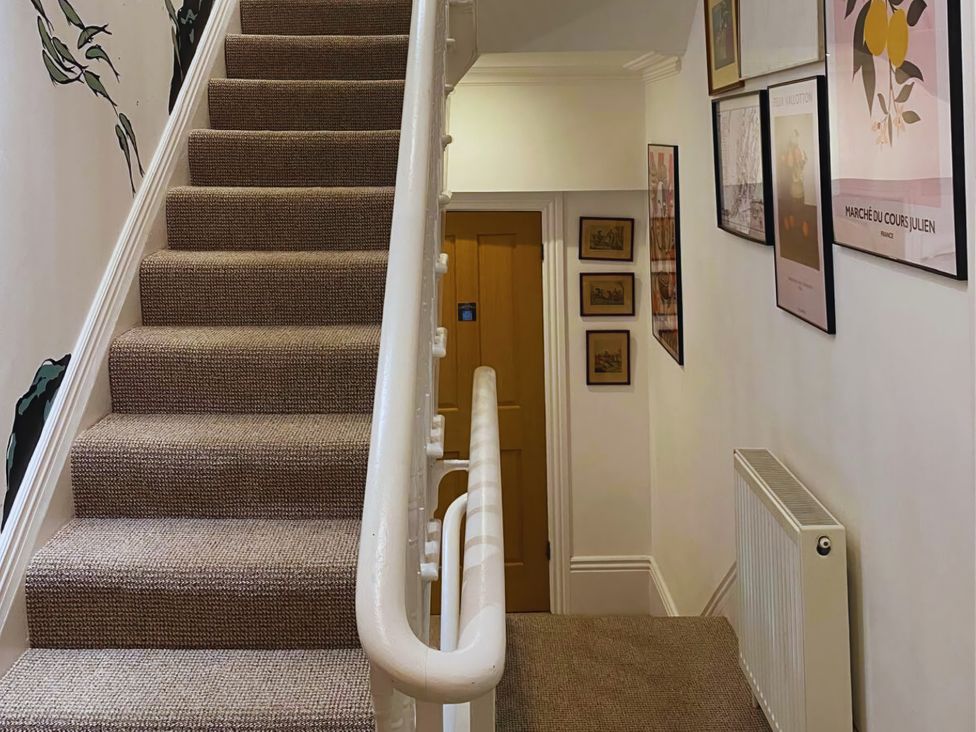 A staircase with framed pictures in the hallway at 21 Gensing Road in St. Leonards-on-Sea