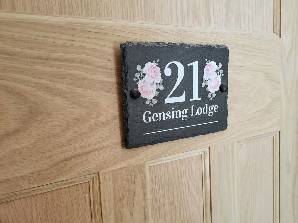 A door sign with the number 21 and Gensing Lodge on a wooden door at 21 Gensing Road St. Leonards-on-Sea