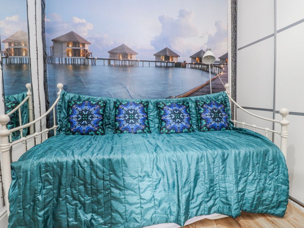 A daybed with cushions and a wall mural at Number 8 in Blackpool