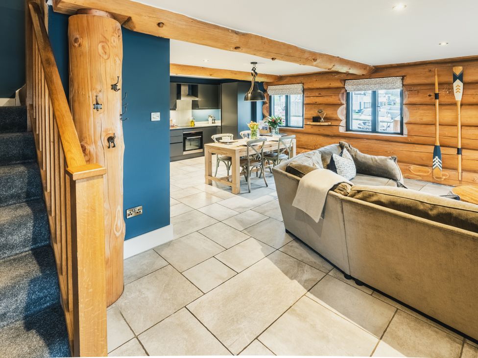 A living room with a staircase, sofa, dining table and kitchen cabinets at The Lookout in Addingham