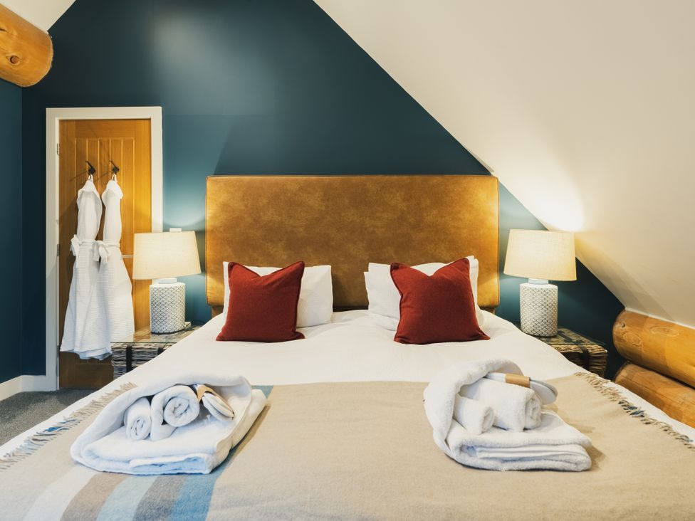 A bedroom with a bed and lamps at The Lookout in Addingham