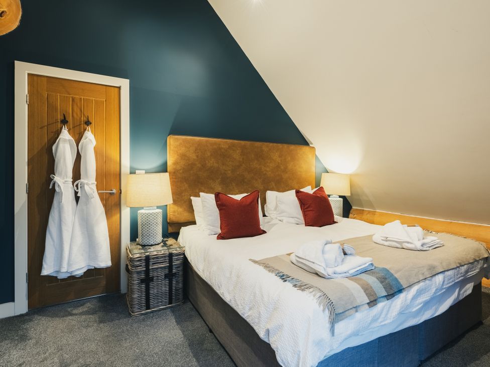 A bedroom with a bed and robes hanging at The Lookout in Addingham