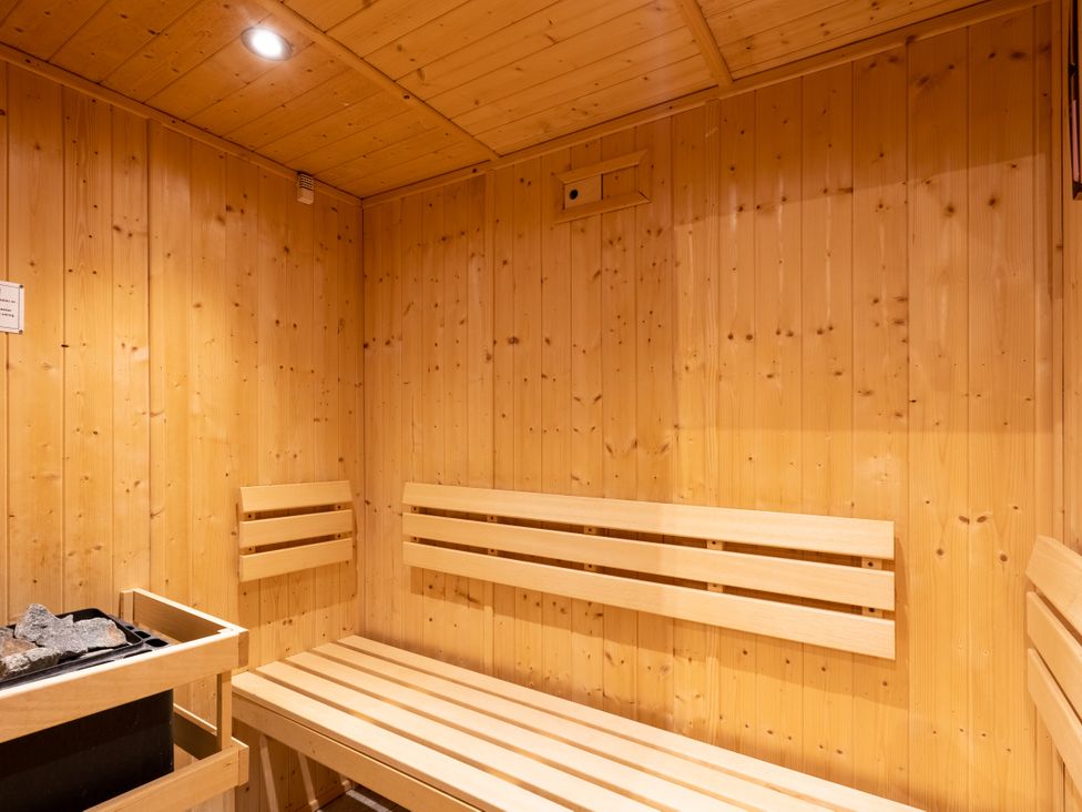 A sauna with wooden benches and a sauna heater at The Lookout in Addingham