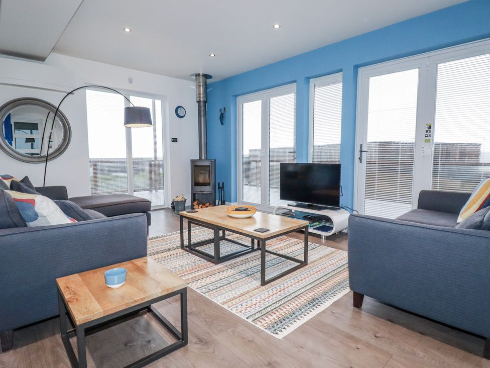 A living room with a coffee table and television at Pentewan in Redruth