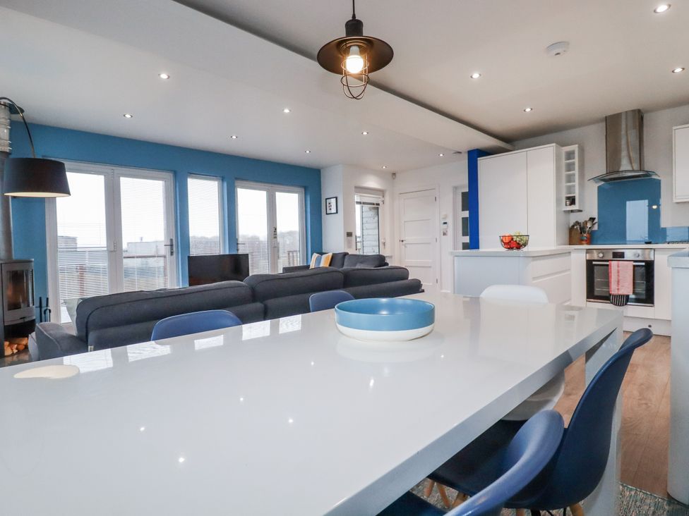 A living room with a sofa and dining table at Pentewan in Redruth