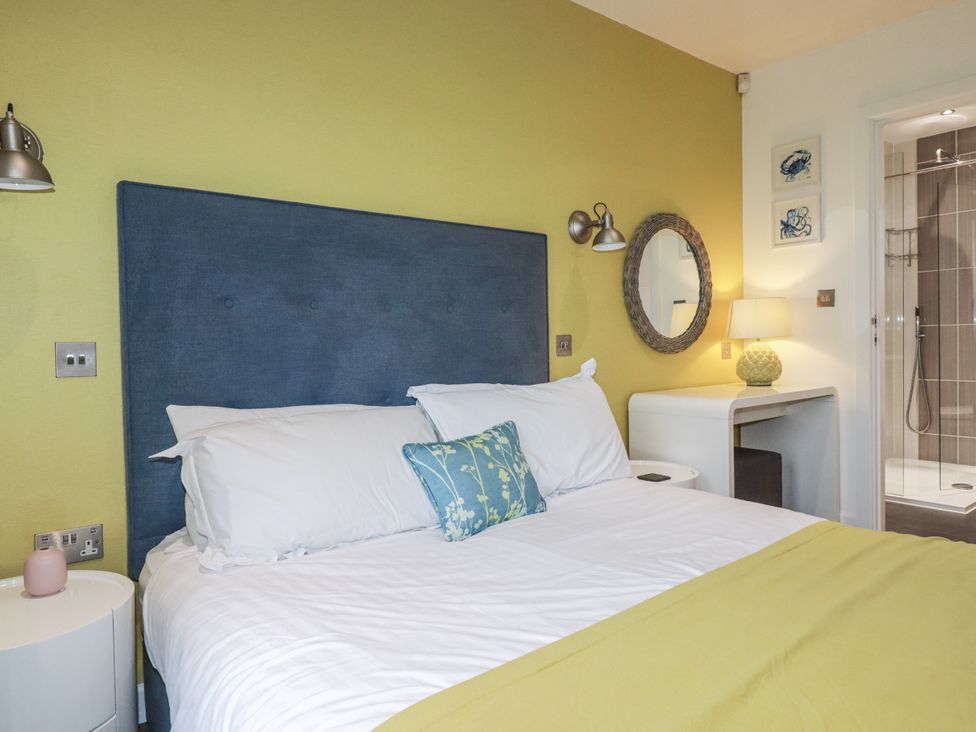A bedroom with a bed and bedside table at Pentewan in Redruth