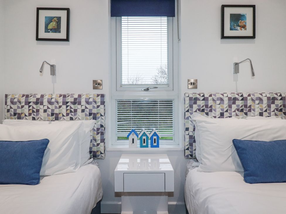 A bedroom with two beds and decorative items at Pentewan in Redruth