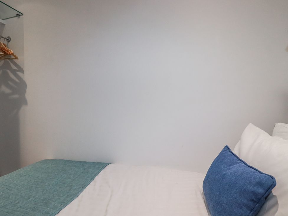 A bedroom with a bed and hanging space at Pentewan in Redruth