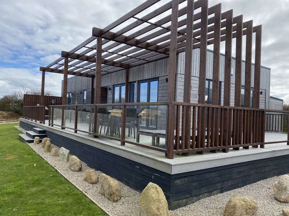 A house with a deck and glass railing at Pentewan Redruth