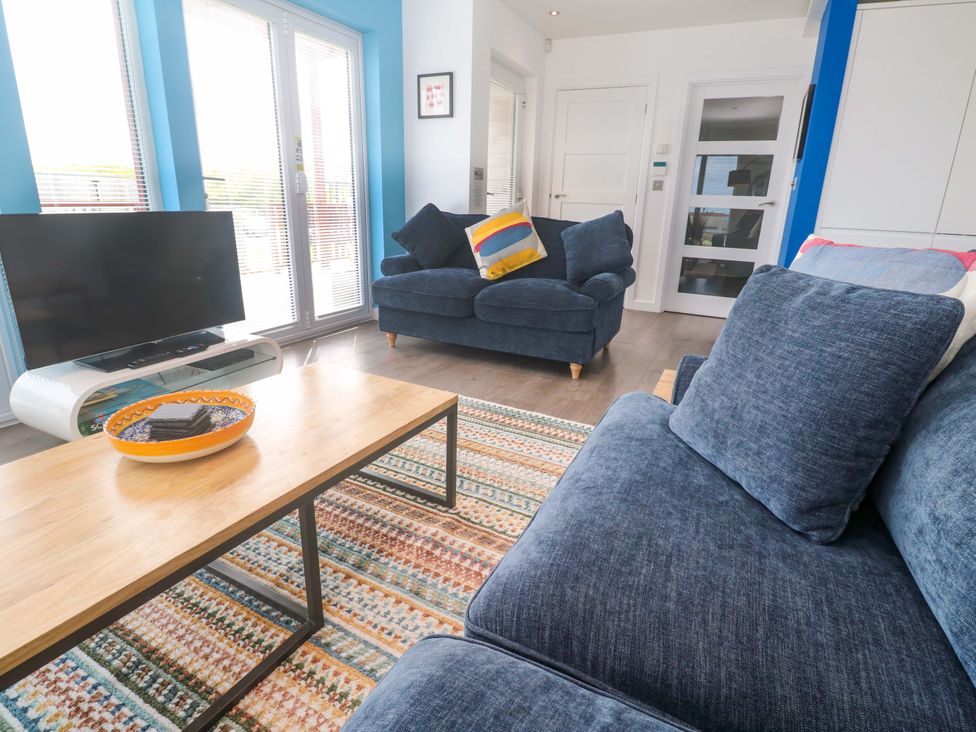 A living room with a television and a coffee table at Pentewan - 67 Portreath