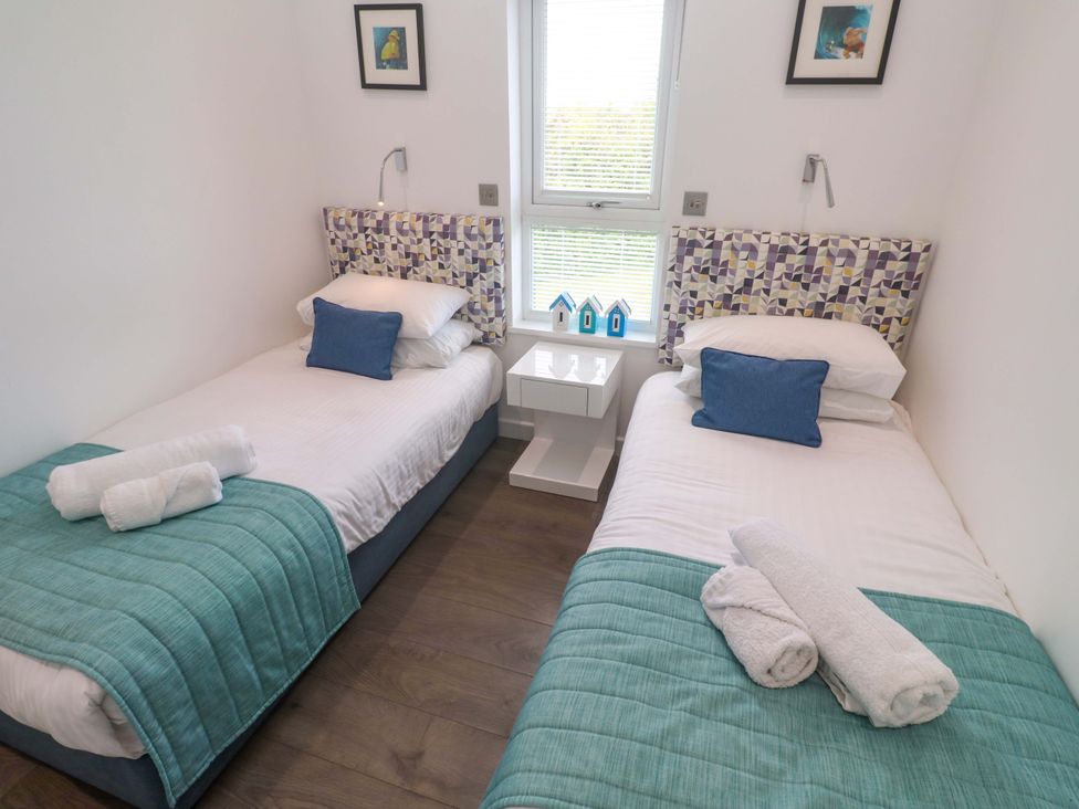 A bedroom with two single beds and a bedside table at Pentewan - 67, Portreath