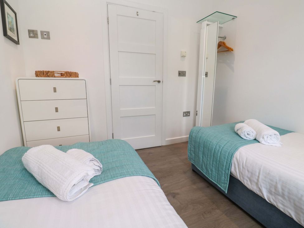 A bedroom with twin beds and a chest of drawers at Pentewan - 67 Portreath