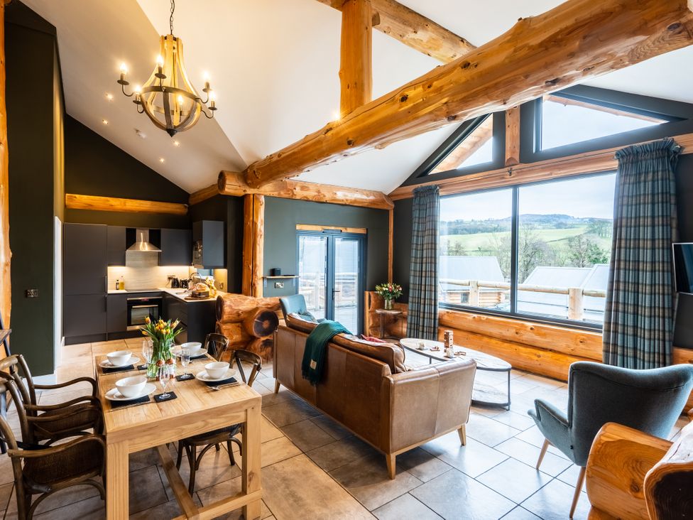 A living room with a dining table and kitchen area at Bears Den in Addingham