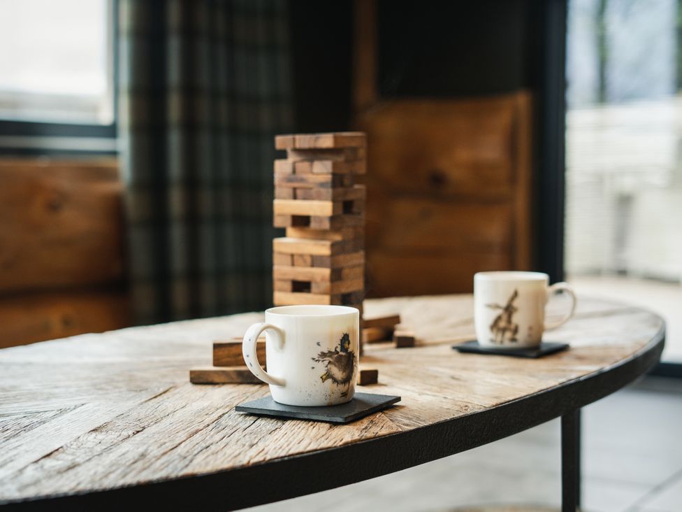 A living room with coffee cups and a wooden block game at Bears Den in Addingham