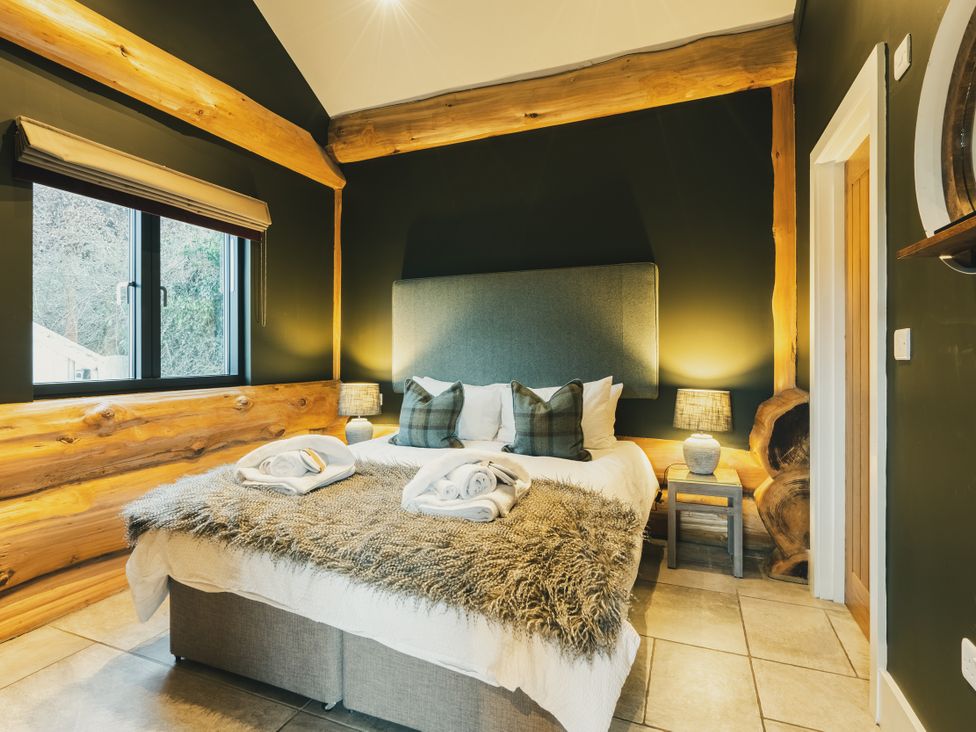 A bedroom with a bed and window at Bears Den in Addingham