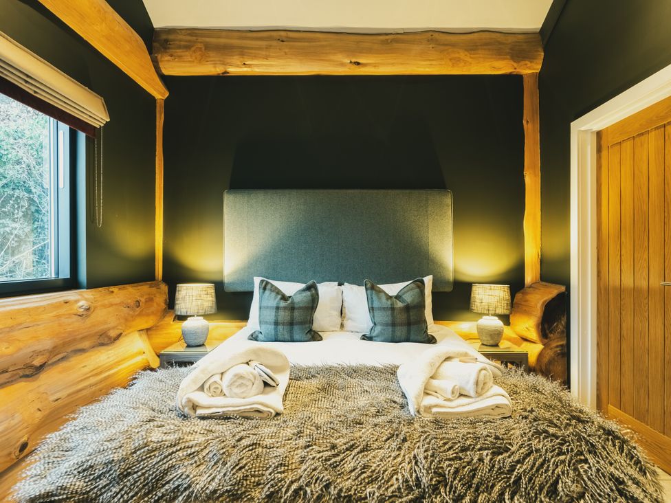 A bedroom with a bed and bedside lamps at Bears Den in Addingham
