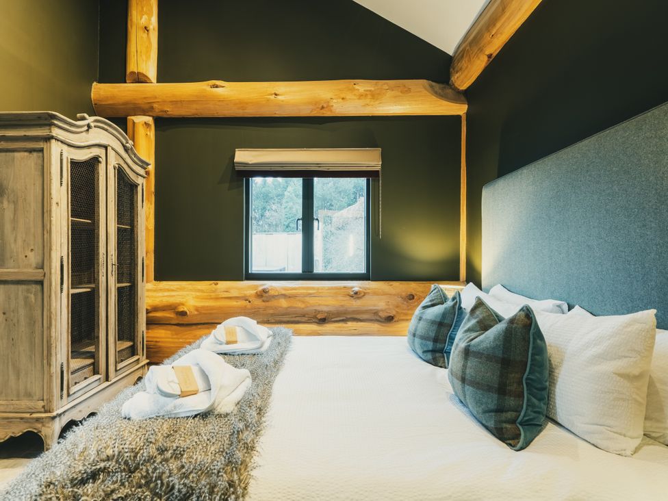 A bedroom with a bed and cabinet at Bears Den in Addingham