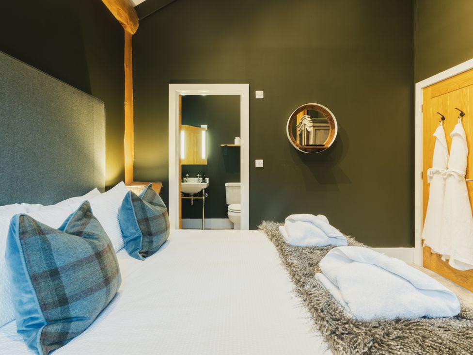 A bedroom with a bed and bathroom visible at Bears Den in Addingham