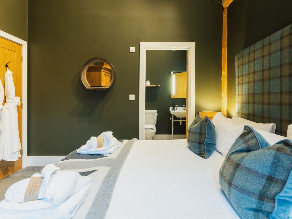 A bedroom with a bed and bathroom in view at Bears Den in Addingham