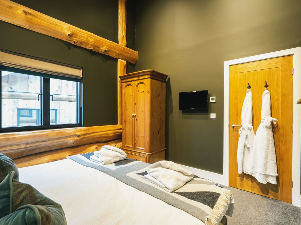 A bedroom with a bed and wardrobe at Bears Den in Addingham