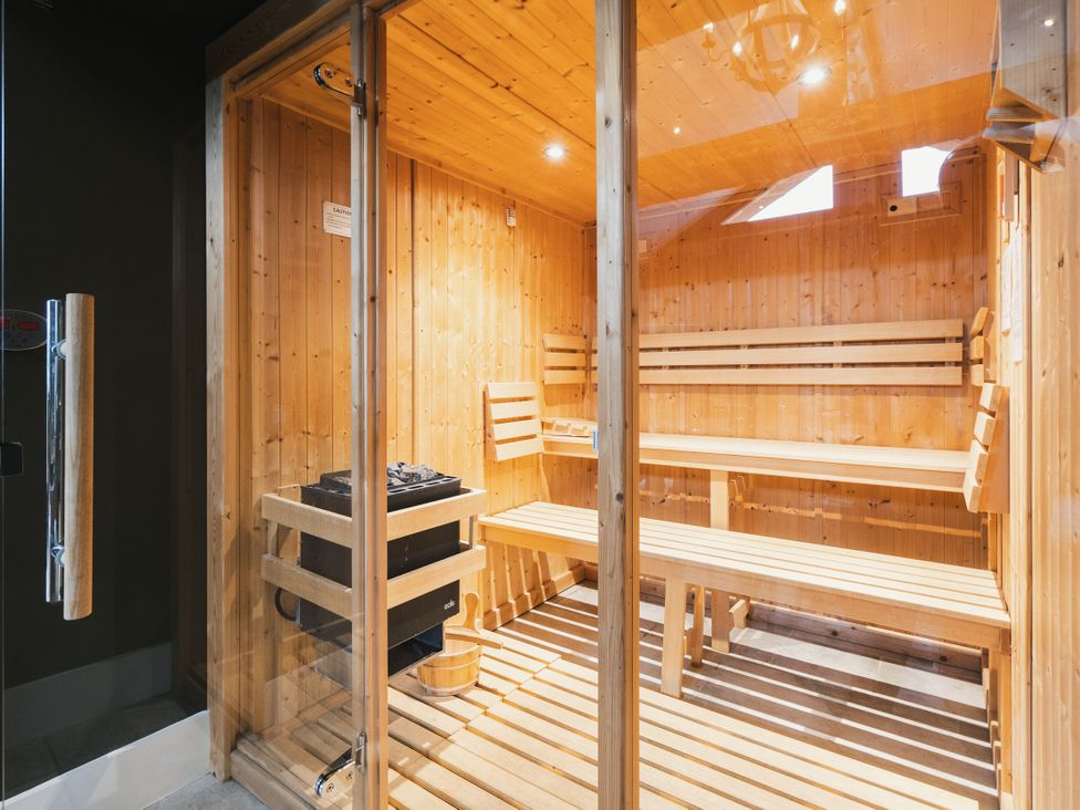 A sauna with wooden benches and a stove at Bears Den in Addingham