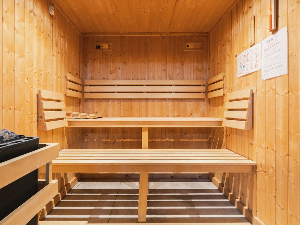 A sauna with wooden benches and a stone heater at Bears Den in Addingham