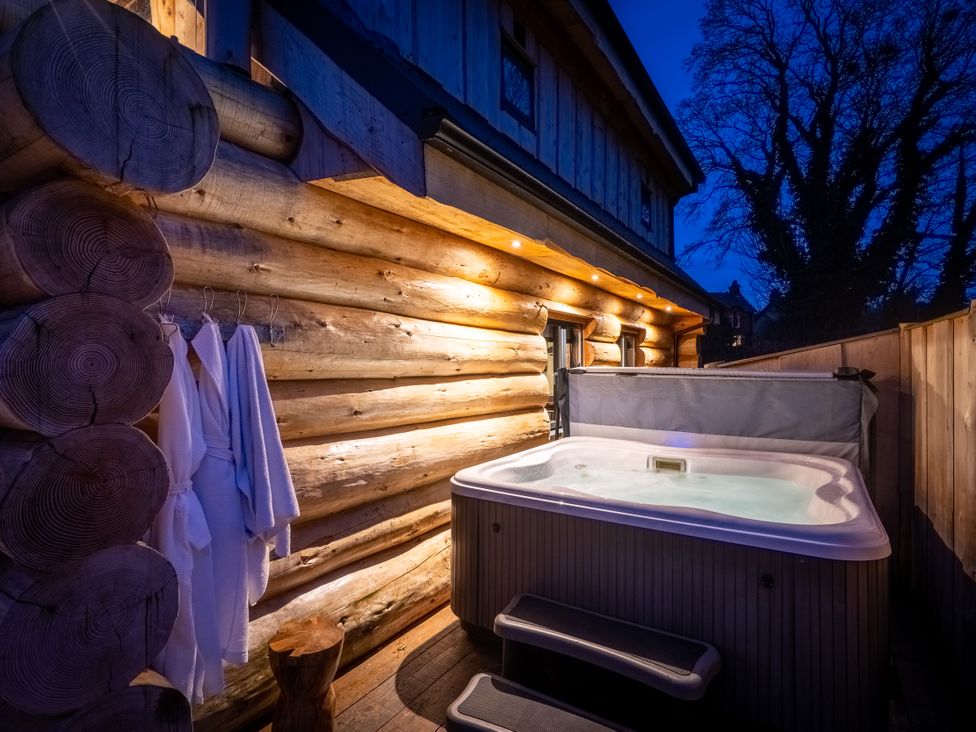 An outdoor area with a hot tub and robes at Bears Den in Addingham