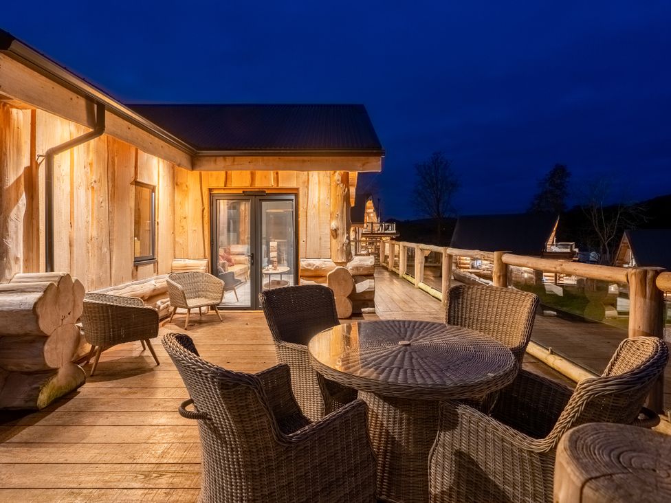 An outdoor deck area with a table and chairs at Bears Den in Addingham