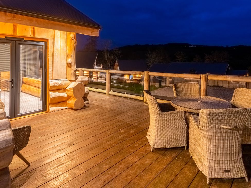 An outdoor deck with a table and chairs at Bears Den in Addingham
