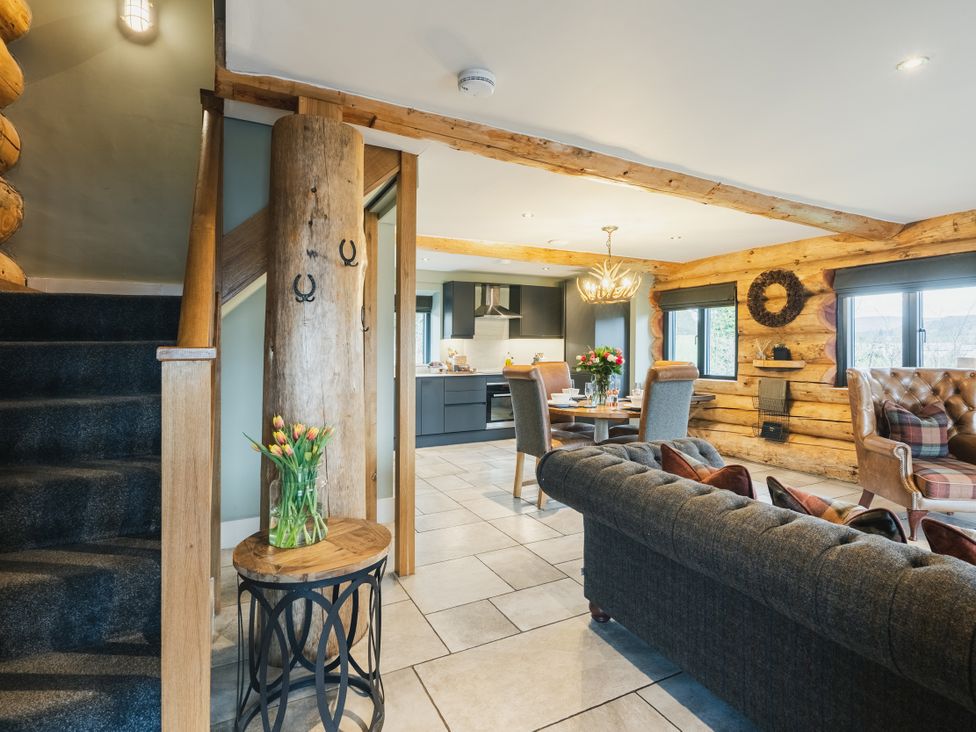 A living room with a staircase and kitchen area at Keepers Cabin in Addingham