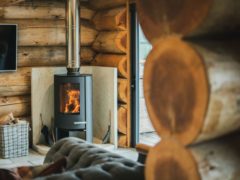 A living room featuring a fireplace and a television at Keepers Cabin in Addingham